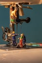 Miniature people change thread on sewing machine