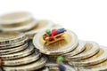 Miniature people : Child having fun to play slider on coins. Royalty Free Stock Photo