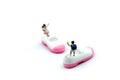 Miniature people : children with baby shoes. Royalty Free Stock Photo