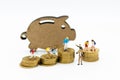 Miniature people: Children group with Piggy bank standing and stack of coins. Image use for investment, saving money