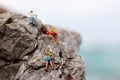 Miniature people: Climber looking up while climbing challenging