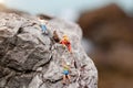 Miniature people: Climber looking up while climbing challenging