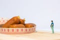 Miniature people : Close up fat man standing in waist tape measure and looking at sausages Royalty Free Stock Photo