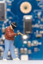 Miniature people Computer repair technicians repair an electronic board with gas Royalty Free Stock Photo