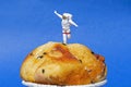 Miniature People concept, close up miniature astronaut standing on muffin, over blue background.