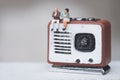Miniature people couple sitting on radio retro. Concept of good old memories Royalty Free Stock Photo