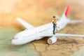 Miniature people : Couples traveling by airplane, plane on a world map, used as a business travel concept Royalty Free Stock Photo