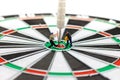 Miniature people digging the arrow in the middle of the target to the dart board. Concept of doing for goals Royalty Free Stock Photo