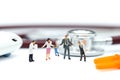 Miniature people: doctor and Family standing with stethoscope an