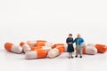 Miniature people - Elderly people posing in front of pills