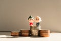Miniature people, elderly people sitting on stack coins Royalty Free Stock Photo