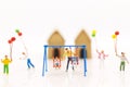Miniature people : father swing cradle with children, and childrens play balloon together wiht fun