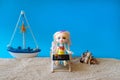 Miniature people girl with pink hair sits in a deck chair with a laptop and a glass of drink in her hands and looks at the sea. Royalty Free Stock Photo