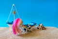 Miniature people girl with pink hair sits in a deck chair with a laptop and a glass of drink in her hands and looks at the sea. Royalty Free Stock Photo