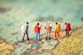 Miniature people: Group of backpacker on vintage world map