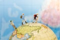 Miniature people: Group traveler backpack stand and walking on world map. Image use for travelling or business trip concept Royalty Free Stock Photo