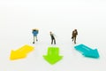 Miniature people: Guys standing on front of arrow pathway choice. Image use for Business decision concept