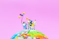 Miniature people : Happy family holding balloon on The globe wit Royalty Free Stock Photo