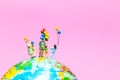 Miniature people : Happy family holding balloon on The globe wit Royalty Free Stock Photo