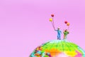 Miniature people : Happy family holding balloon on The globe wit Royalty Free Stock Photo