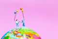 Miniature people : Happy family holding balloon on The globe wit Royalty Free Stock Photo