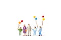 Miniature people : Happy family holding balloon on white background Royalty Free Stock Photo