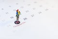 Miniature people holding balloon stand on the calenda, Merry Christmas. Royalty Free Stock Photo