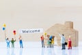 Miniature people holding Welcome signs at front of the home Royalty Free Stock Photo