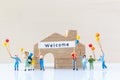 Miniature people holding Welcome signs at front of the home Royalty Free Stock Photo