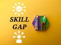 Miniature people and icon with text SKILL GAP Royalty Free Stock Photo