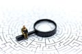 Miniature people: Magnifying glass focusing on the selected of b
