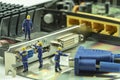 Miniature people maintenance electronic device component Royalty Free Stock Photo