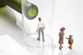 Miniature people. man addicted to alcohol on the background of a bottle of wine and a glass and a broken family. the problem of Royalty Free Stock Photo