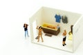 Miniature people : man is hiding behind bathroom Spying. Voyeur