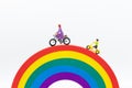 Miniature people : Mom and kids cycling on the rainbow. Image use for to be good model, family concept