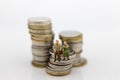 Miniature people, Old couple figure sitting on top of stack coins using as background retirement planning, Life insurance concept. Royalty Free Stock Photo