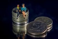 Miniature people, old couple figure sitting on top of stack of Ruble coins using as background retirement planning, life insurance Royalty Free Stock Photo