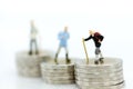 Miniature people: Old people standing on top of stack coins . Image use for background retirement planning, Life insurance