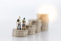 Miniature people: Old people standing on top of stack coins . Image use for background retirement planning, Life insurance concept