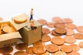 Miniature people, People use the fishing rod to take money from the floor and drop stack coins in the box. Royalty Free Stock Photo