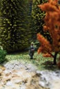 Miniature people: relaxed businessman standing in the forest. Working outdoor green nature concept. Macro photo, shallow DOF. Royalty Free Stock Photo