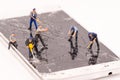 Miniature people repair smartphone crack