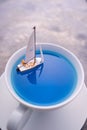Miniature people, Rowing boat in the ocean in cup.  Image use for life style concept Royalty Free Stock Photo
