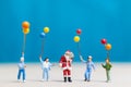 Miniature people: Santa Claus and children holding balloon Royalty Free Stock Photo