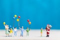 Miniature people: Santa Claus and children holding balloon Royalty Free Stock Photo