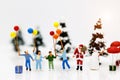 Miniature people: Santa Claus and childrens holding balloon with Christmas Tree. Royalty Free Stock Photo