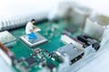 Miniature people searching or checking for bugs and issue on microchip, mainboard of computer. Vulnerability search and security