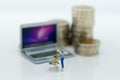 Miniature people: a shopper pushes a shopping cart with notebook. Image use for retail business , shopping online concept