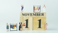 Miniature people Shopping at Women`s clothing store.Wooden letters write the word November and the numbers 11 on white background Royalty Free Stock Photo