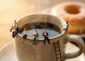 Miniature people sitting on coffee cup edge creative teamwork concept Royalty Free Stock Photo